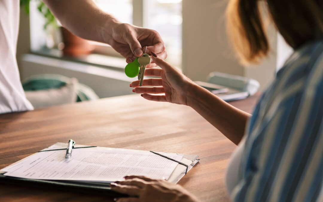 Cropped image of owner giving house keys to tenant after filling rental forms