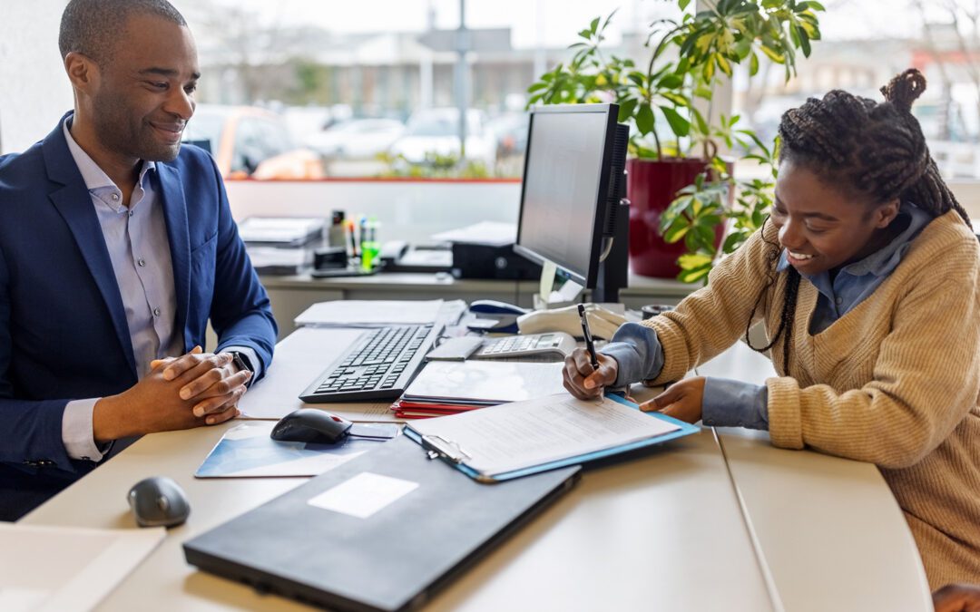 Woman signing contract documents with sales manager for lease agreement